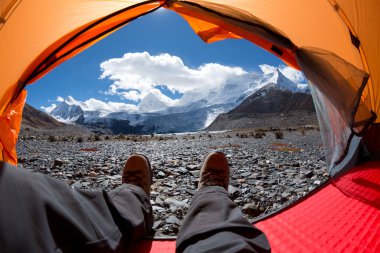 Yürüyüşçü çadırdaki güzel manzaranın tadını çıkar.