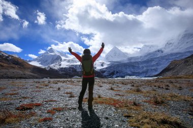 Kış dağlarında yürüyüş yapan bir kadın.