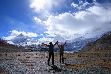 Kış dağlarında yürüyüş yapan iki kadın.