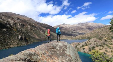 Güzel kış dağlarında yürüyüş yapan iki kadın gezgin.