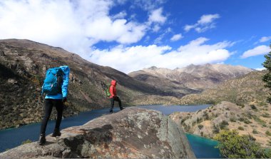 Güzel kış dağlarında yürüyüş yapan iki kadın gezgin.