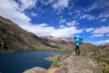 Güzel kış dağlarında fotoğraf çeken kadın fotoğrafçı.