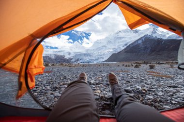 Yürüyüşçü çadırdaki güzel manzaranın tadını çıkar.
