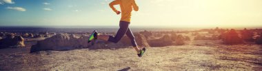 Fitness kadını, kum çölünde koşan bir koşucunun izini sürüyor.