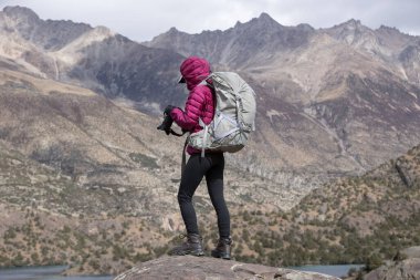 Güzel kış dağlarında fotoğraf çeken bir kadın.