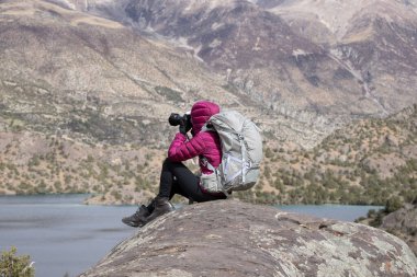 Güzel kış dağlarında fotoğraf çeken bir kadın.