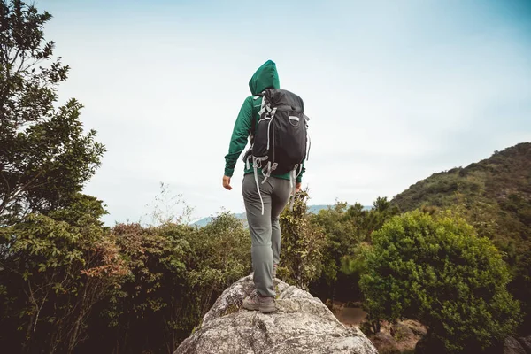 Woman hiker hiking in winter tropical mountains