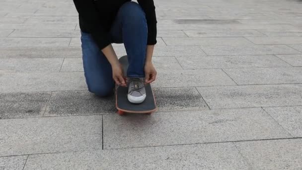 Junge Frau Schnürt Schnürsenkel Auf Skateboard Und Reitet — Stockvideo