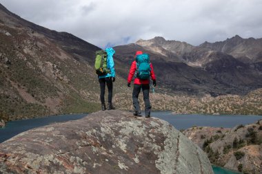 Güzel kış dağlarında yürüyüş yapan iki kadın gezgin.