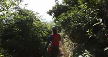 Genç bir kadın ormanda koşuyor.