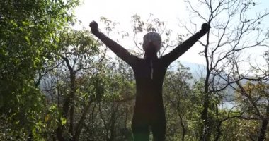 Orman bölgesinde kolları açık duran bir kız.