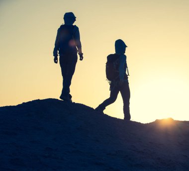 İki kadın gezgin çölde yürüyüş yapıyor.