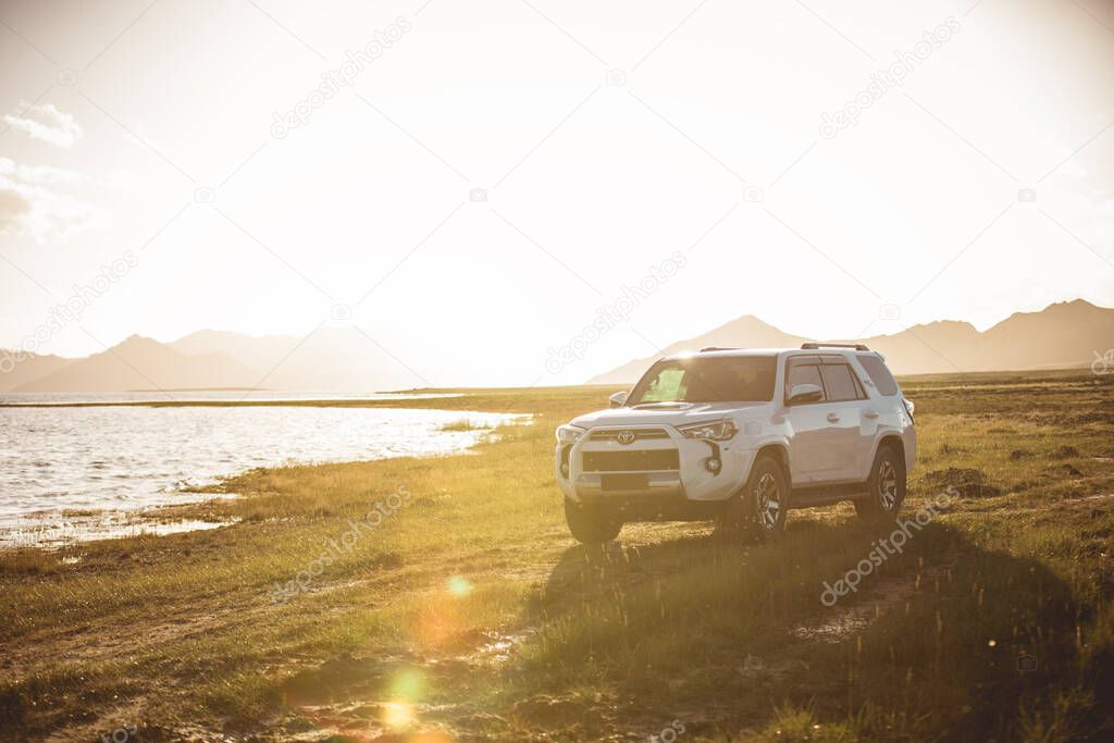 Qinghai,China - Circa 2020:  Driving White 2020 Toyota 4Runner TRD crossing in the sunset lakeside trip 