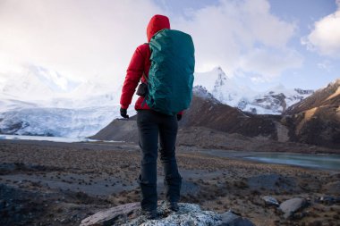 Kış dağlarında yürüyüş yapan başarılı bir kadın.