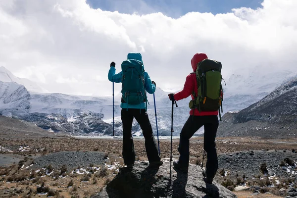 冬の標高の高い山をハイキングする2人の女性 — ストック写真