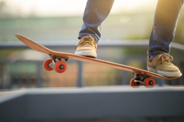 Kaykaycı bacakları açık havada kaykay yapıyor.