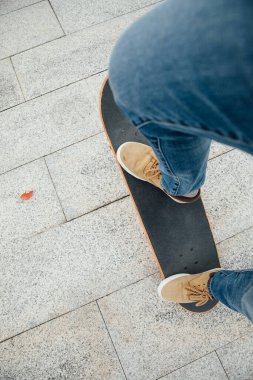 Kaykaycı bacakları açık havada kaykay yapıyor.  