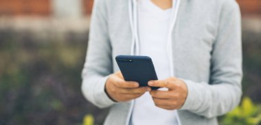 Şehirde akıllı telefon kullanan Asyalı bir kadın.