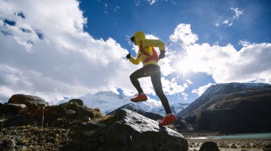 Yüksek irtifada kış mevsiminde koşan kadın koşucu.