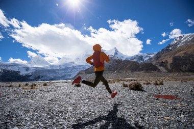 Yüksek irtifada kış mevsiminde koşan kadın koşucu.