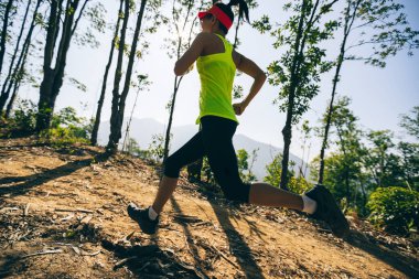 Gündoğumu tropikal ormanlarında koşan genç bir kadın koşucu.