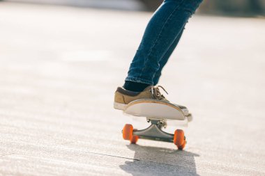 Kaykaycı güneşli bir sabahta dışarıda kaykay yapıyor.