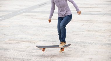 Modern şehirde Asyalı kaykaycı kadın.