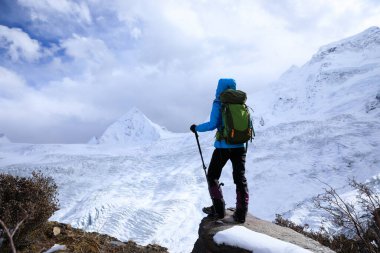 Kış dağlarında yürüyüş yapan başarılı bir kadın.