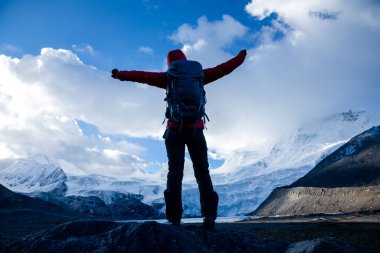 Kış dağlarında yürüyüş yapan başarılı bir kadın.