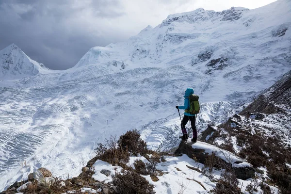 Kış dağlarında yürüyüş yapan başarılı bir kadın.