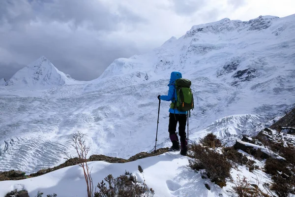 Kış dağlarında yürüyüş yapan başarılı bir kadın.