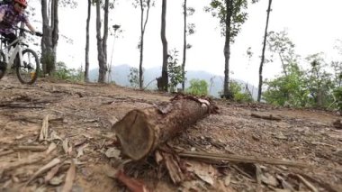 Ormanda bisiklete binen ve atlayan bir kadın.