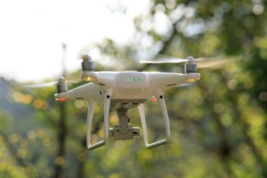 Baharda tropikal ormanda uçan kameralı beyaz dron