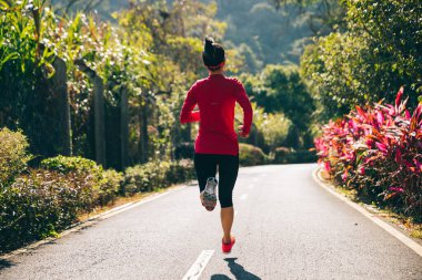 Fitness kadın koşucusu kış parkı yolunda koşuyor
