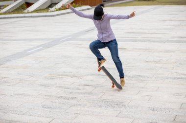 Modern şehirde Asyalı kaykaycı kadın.