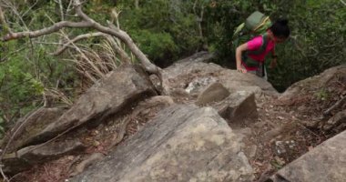 Dişi yürüyüşçü kayalık dağlara tırmanıyor.