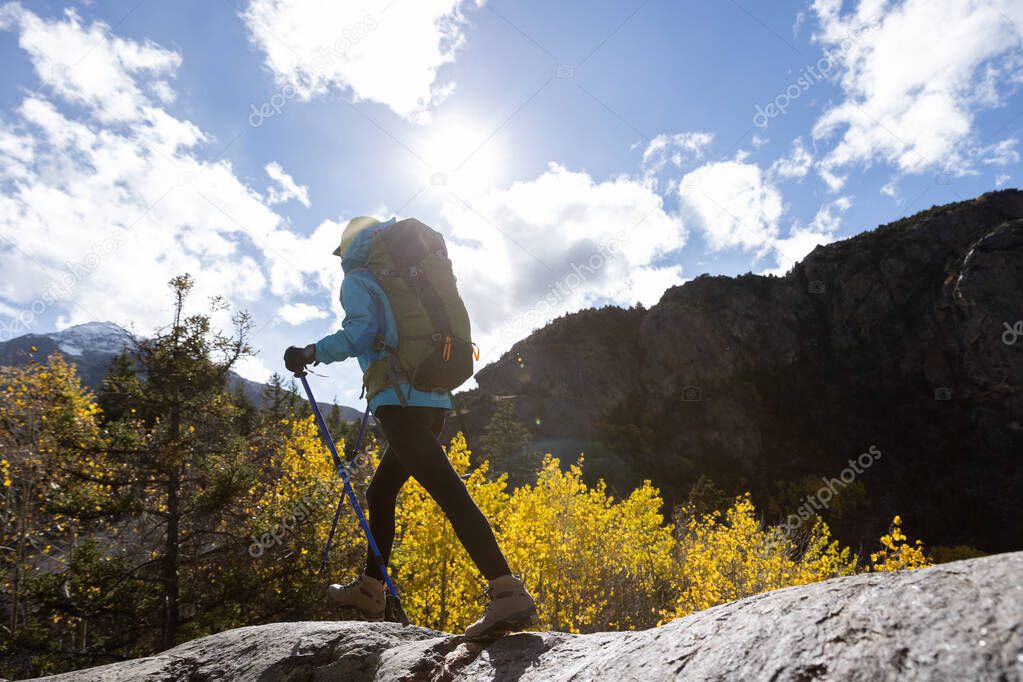 Woman backpacker hiking  in beautiful winter mountains