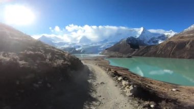 Göl kenarındaki dağlarda hareket eden güzel bir off-road arabası manzarası.