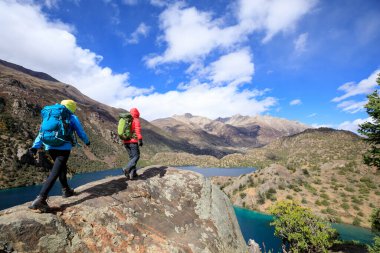 Güzel kış dağlarında yürüyüş yapan iki kadın gezgin.