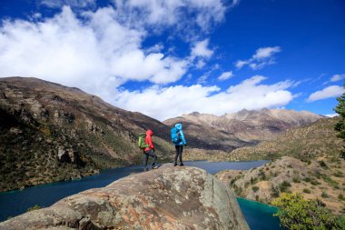 Güzel kış dağlarında yürüyüş yapan iki kadın gezgin.