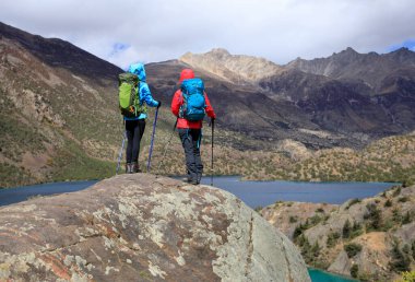 Güzel kış dağlarında yürüyüş yapan iki kadın gezgin.