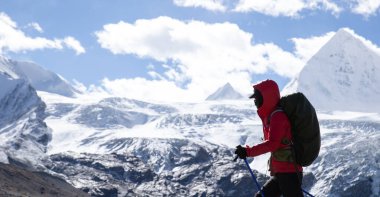Başarılı bir kadın sırt çantalı, yüksek irtifada kış yürüyüşü yapıyor.
