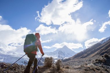 Güçlü kadın sırt çantalı, yüksek irtifa dağlarında yürüyüş yapıyor.