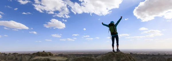 成功的女背包客在沙漠山顶感觉很自由 — 图库照片