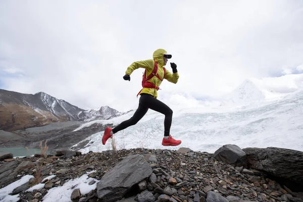 겨울에 눈덮인 산꼭대기를 오르는 산길을 달리는 여자들 — 스톡 사진