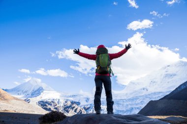Kış dağlarında yürüyüş yapan başarılı bir kadın.