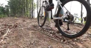 Bisikletli kadın Bahar Dağında Ormanın tepesinde bisiklet sürüyor