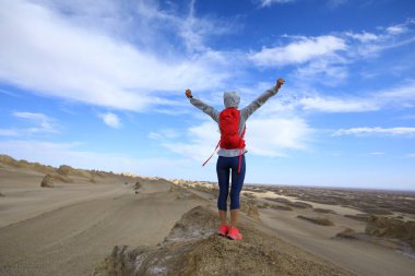 Successful woman trail runner open arms on sand desert dunes clipart