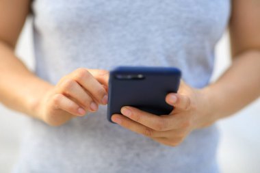 Açık havada akıllı telefon kullanan Asyalı kadın.