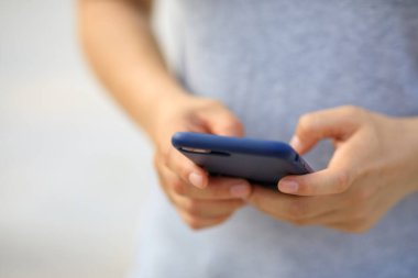 Açık havada akıllı telefon kullanan Asyalı kadın.